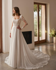 Robe de Mariée Nera collection Alma Novia 2026. Robe col carré manches longues et traîne dentelle. Essayer boutique mariage showroom Paris