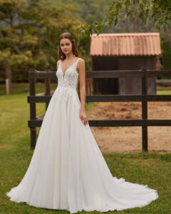 Robe de Mariée Noira collection Alma Novia 2026. Robe tulle dentelle sans manches et dos en V. Essayer boutique mariage showroom Paris