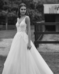 Robe de Mariée Noira collection Alma Novia 2026. Robe tulle dentelle sans manches et dos en V. Essayer boutique mariage showroom Paris
