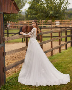 Robe de Mariée Nolir collection Alma Novia 2026. Robe tulle dentelle manches longues et dos en V. Essayer boutique mariage showroom Paris