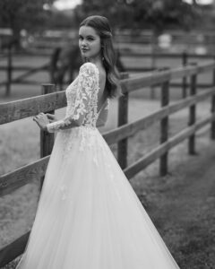 Robe de Mariée Nolir collection Alma Novia 2026. Robe tulle dentelle manches longues et dos en V. Essayer boutique mariage showroom Paris
