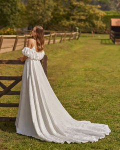 Robe de Mariée Nithan collection Alma Novia 2026. Robe tissu épais fente avec cape. Sexy et simple. Essayer boutique mariage showroom Paris