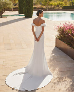 Robe de Mariée Sabila Adriana Alier 2026. Robe bustier stylée grosses fleurs blanches épaules tombantes. Essayer boutique mariage Paris