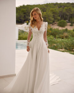 Robe de Mariée Salome Adriana Alier 2026. Robe dentelle fluide et manteau cape traîne. Essayer RDV boutique mariage showroom Paris