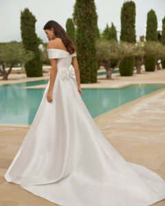 Robe de Mariée Sulina Adriana Alier 2026. Robe volume simple mikado sans dentelle, col bardot et fendue. Essayer boutique mariage Paris