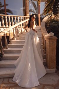 Robe de mariée Antares. Robe glamour brocart blanc fines bretelles sexy fente fendue. Essayer boutique mariage Paris showroom RDV