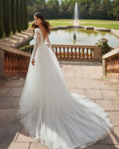 Robe de Mariée Delia Adriana Alier 2026. Robe dentelle volume fente fendue manches longues amovibles. Essayer RDV boutique mariage Paris