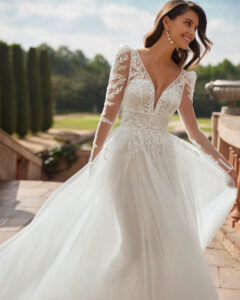 Robe de Mariée Delia Adriana Alier 2026. Robe dentelle volume fente fendue manches longues amovibles. Essayer RDV boutique mariage Paris