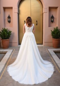 Robe de mariée Curvy Captivée nouvelle collection 2025. Robe grandes tailles col bateau dentelle et tulle. Boutique mariage bohème Paris RDV