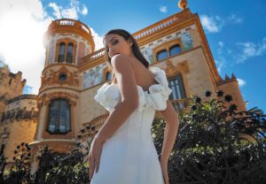 Robe de mariée Victoria sans dentelle chic sexy. Robe satin blanc ivoire. Epaules asymetriques volants. boutique mariage Paris petit prix