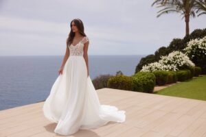 Robe de mariée doridis bianco evento. Robe fluide dentelle fine, pétales petites manches. Essayer boutique mariage Paris showroom RDV