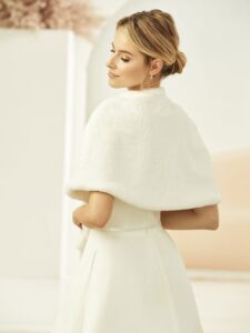 Cape courte de mariée en fausse fourrure blanche ivoire. Accessoire de mariage à porter sur les épaules. Acheter en ligne et boutique mariage Paris