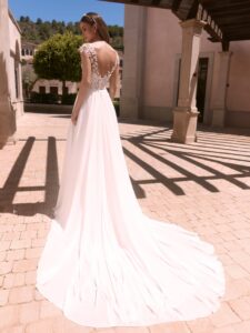 Robe de mariée doridis bianco evento. Robe fluide dentelle fine, pétales petites manches. Essayer boutique mariage Paris showroom RDV