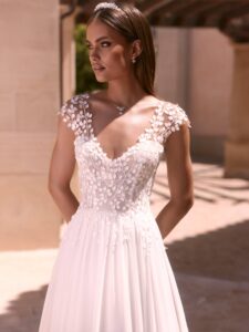 Robe de mariée doridis bianco evento. Robe fluide dentelle fine, pétales petites manches. Essayer boutique mariage Paris showroom RDV