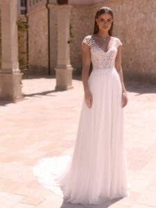Robe de mariée doridis bianco evento. Robe fluide dentelle fine, pétales petites manches. Essayer boutique mariage Paris showroom RDV
