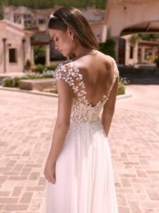 Robe de mariée doridis bianco evento. Robe fluide dentelle fine, pétales petites manches. Essayer boutique mariage Paris showroom RDV