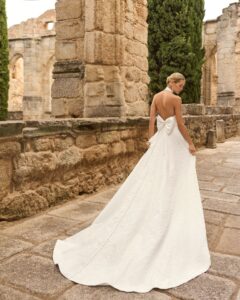 Robe de Mariée Prado Adriana Alier 2027 boutique mariage paris. robe col américain évasée fendue matière brocart. Fente ajustable