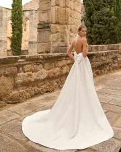 Robe de Mariée Prado Adriana Alier 2027 boutique mariage paris. robe col américain évasée fendue matière brocart. Fente ajustable