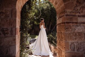 Robe de mariée Comete cosmobella 2027. Robe bustier corset tissu mikado manches tombantes top dentelle. RDV essayage boutique mariage Paris
