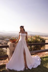Robe de mariée luna cosmobella 2027. Robe bustier en satin fendue et manches tombantes amovibles. RDV essayage boutique mariage Paris